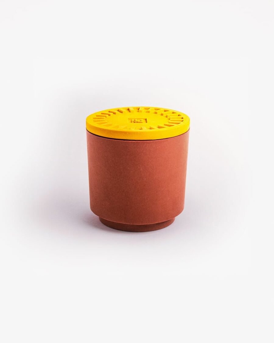 Ethische BANANA kaars met een levendig geel deksel en een terracotta pot, met een zoete bananengeur met hints van limoen en vanille.