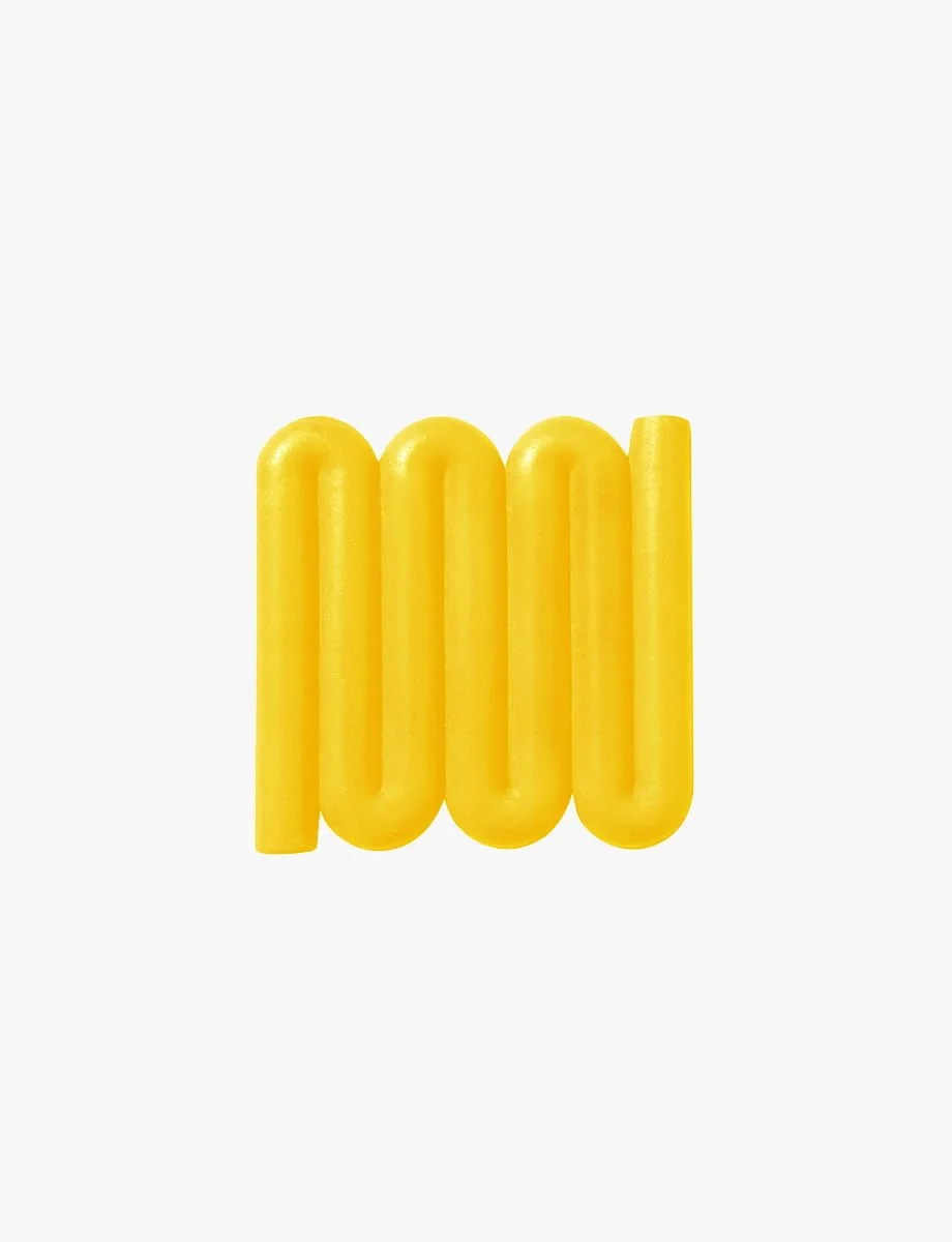 Bright yellow Bandy soap dish with sinuous, curved lines designed for optimal water flow and aeration, inspired by the Australian bandy-bandy snake.