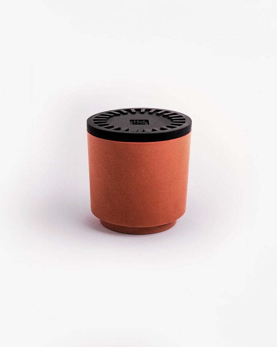 BEYOND THE PINES kaars met een diepzwart deksel en terracotta pot, die een balsamico dennenhoutgeur uitspaalt met tonen van ceder, rozemarijn en eucalyptus.