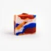 "Handgemaakte 'ORIGINAL GANGSTA'-zeep met levendige wervelingen van blauw, oranje en rood, met exfoliërende paprikavlekken.