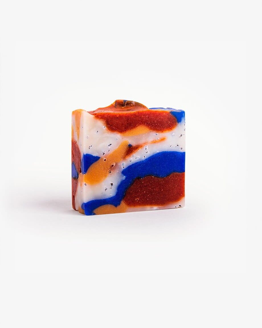 "Handmade 'ORIGINAL GANGSTA' soap with vibrant swirls of blue, orange, and red, featuring exfoliating paprika spots.