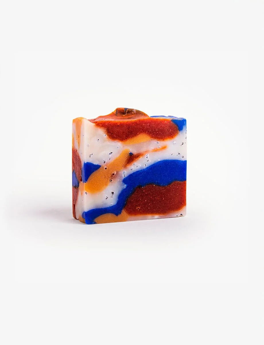 "Handmade 'ORIGINAL GANGSTA' soap with vibrant swirls of blue, orange, and red, featuring exfoliating paprika spots.