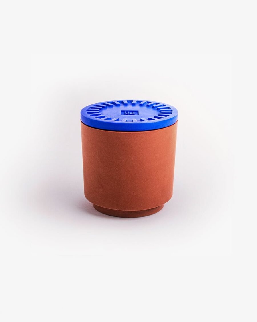 SON OF A BEACH candle in a vibrant blue Jesmonite pot with a terracotta base, exuding scents of lime, mint, salt, and rum for a beachy vibe.