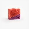 Handmade organic soap with swirls of crimson and purple, embedded with real cranberry and blueberry pieces for nourishing skincare.