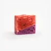 Handmade organic soap with swirls of crimson and purple, embedded with real cranberry and blueberry pieces for nourishing skincare.