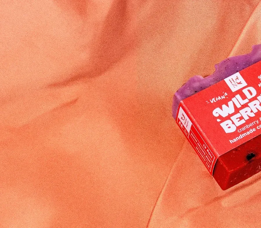 Photography of a Wild Berries bar soap by Hank. Handmade, cold processed soap on a shower curtain.